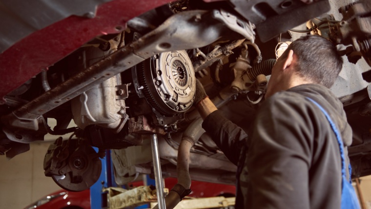 Repair man fixing car in repair station