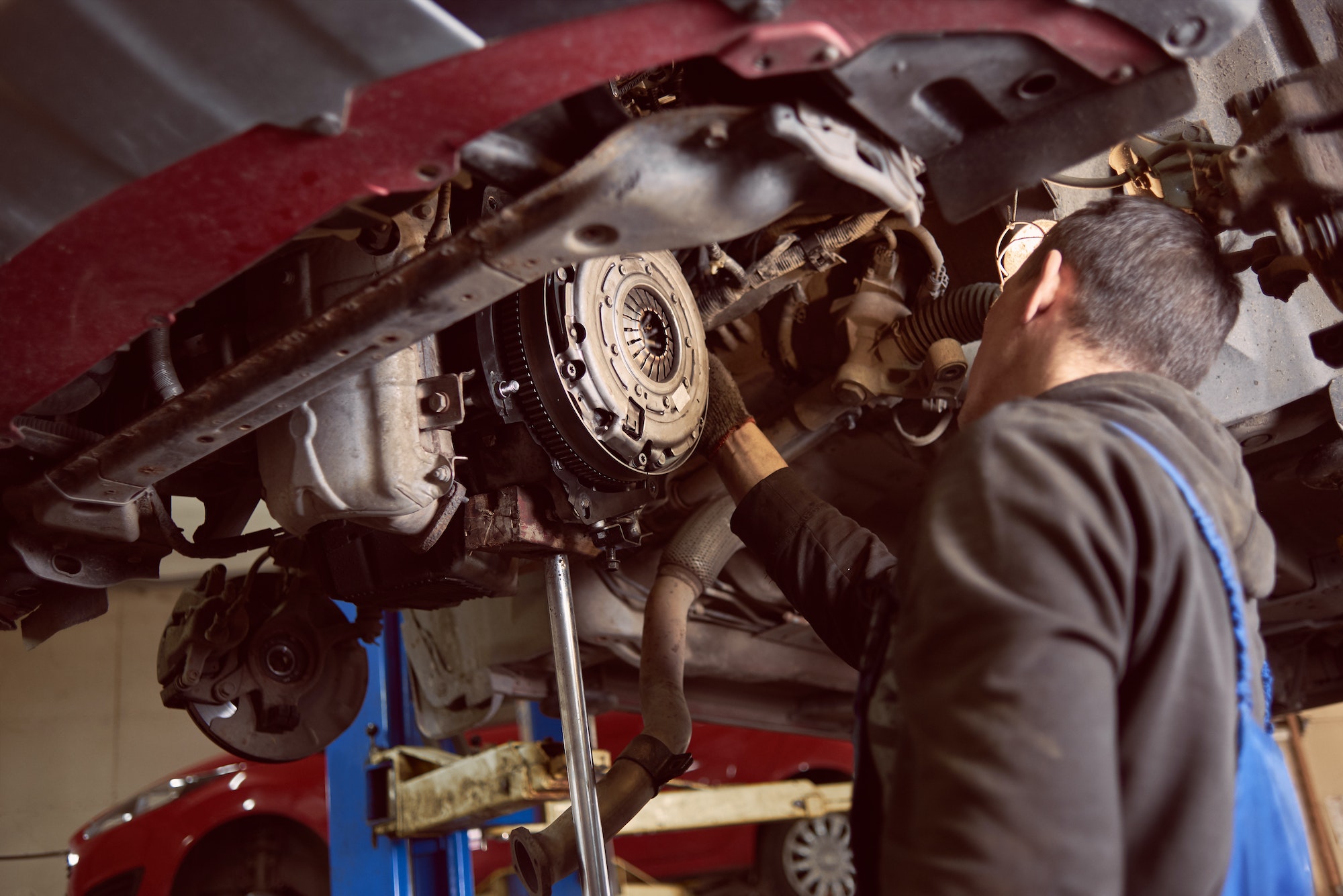 Repair man fixing car in repair station